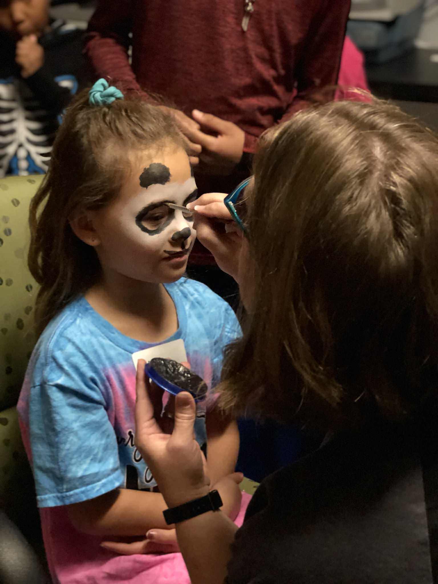 A girl getting her face painted at Camp Angel.
