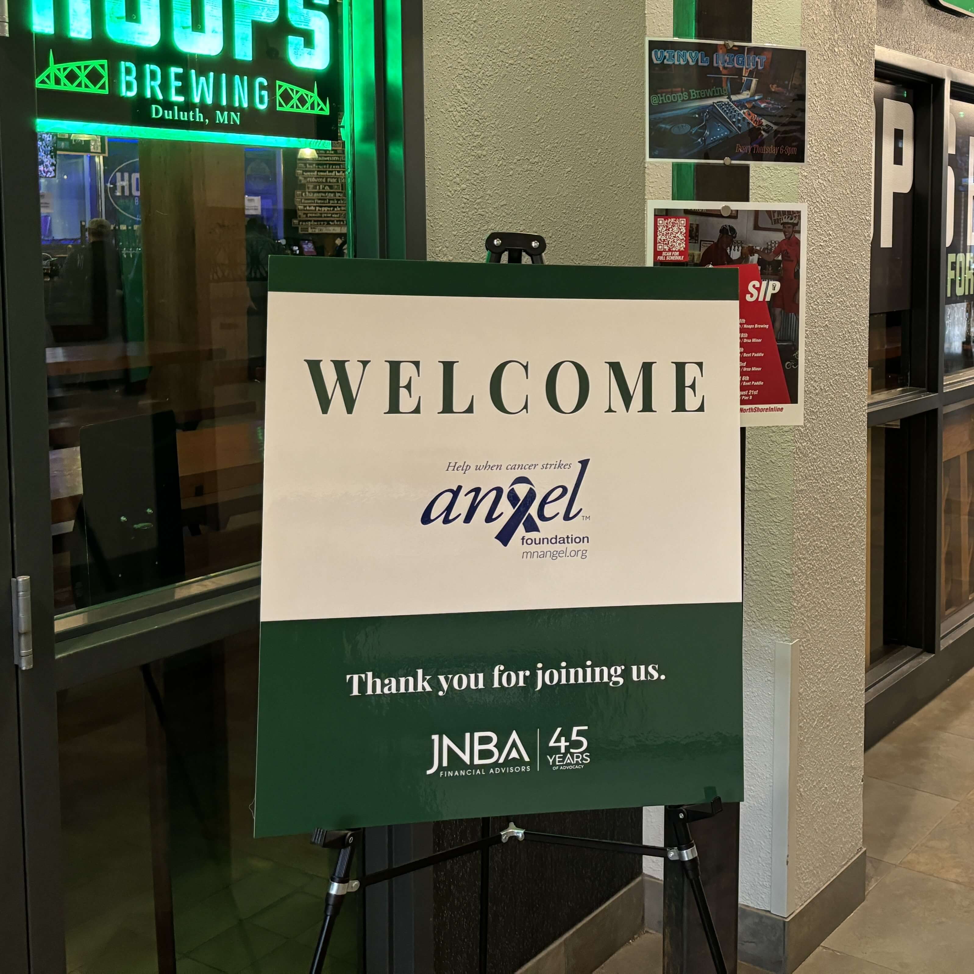 A welcome sign featuring Angel Foundation’s™ logo and a note that says “thank you for joining us” above a JNBA Financial Advisors logo. 