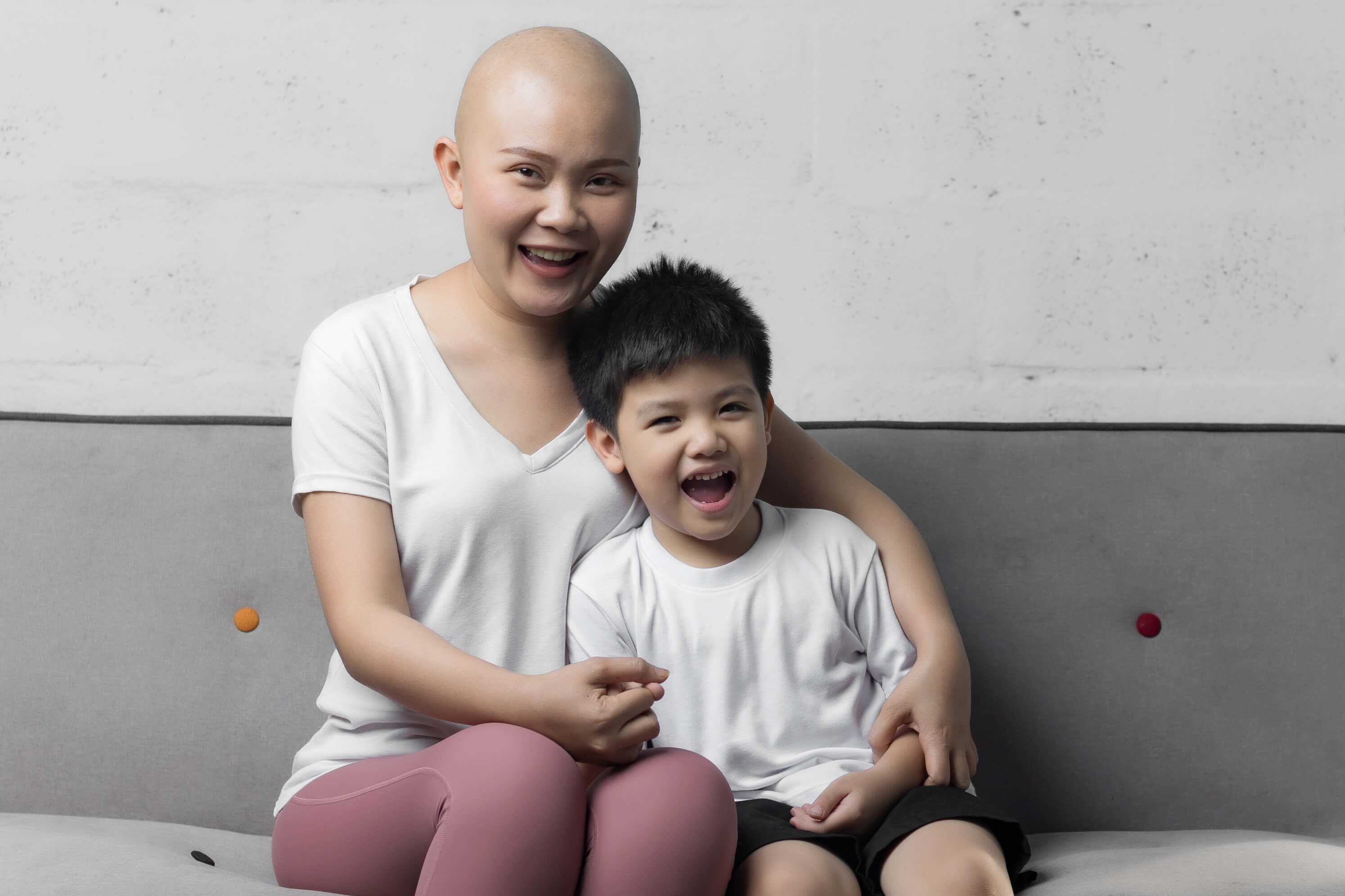 A mother with cancer and her son smiling big.